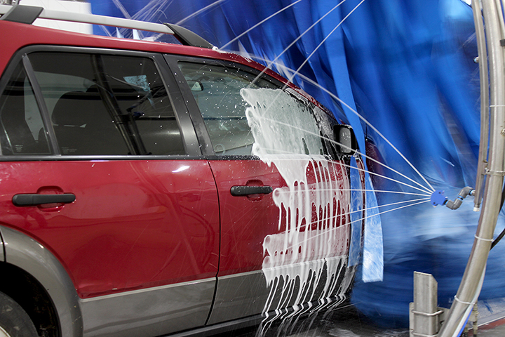 SUV in car wash being sprayed by soap