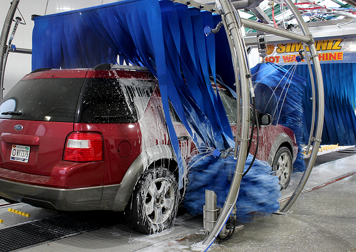 SUV in Soapy Sam's car wash being wiped with mitter curtains